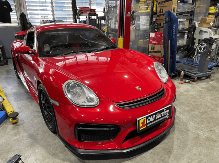 Technician performing Porsche servicing at a professional workshop