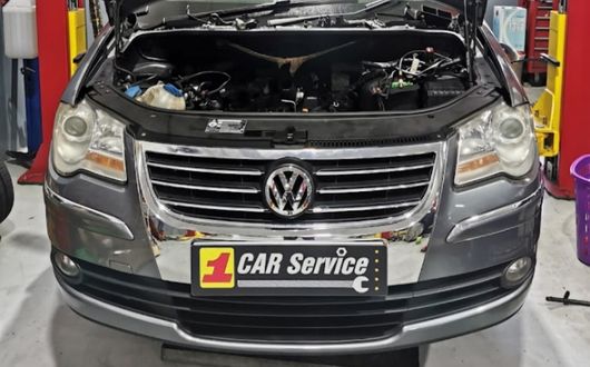 Mechanics performing high-quality repairs and servicing on a Volkswagen vehicle at a professional Volkswagen workshop.