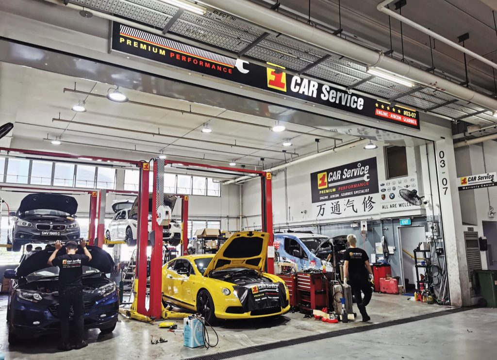 Technicians repairing a car's air conditioning system in best car workshop Singapore.