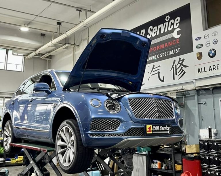 A Bentley undergoing repair in a professional car service workshop.