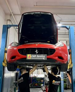 Technicians working on a Ferrari in a state-of-the-art workshop.