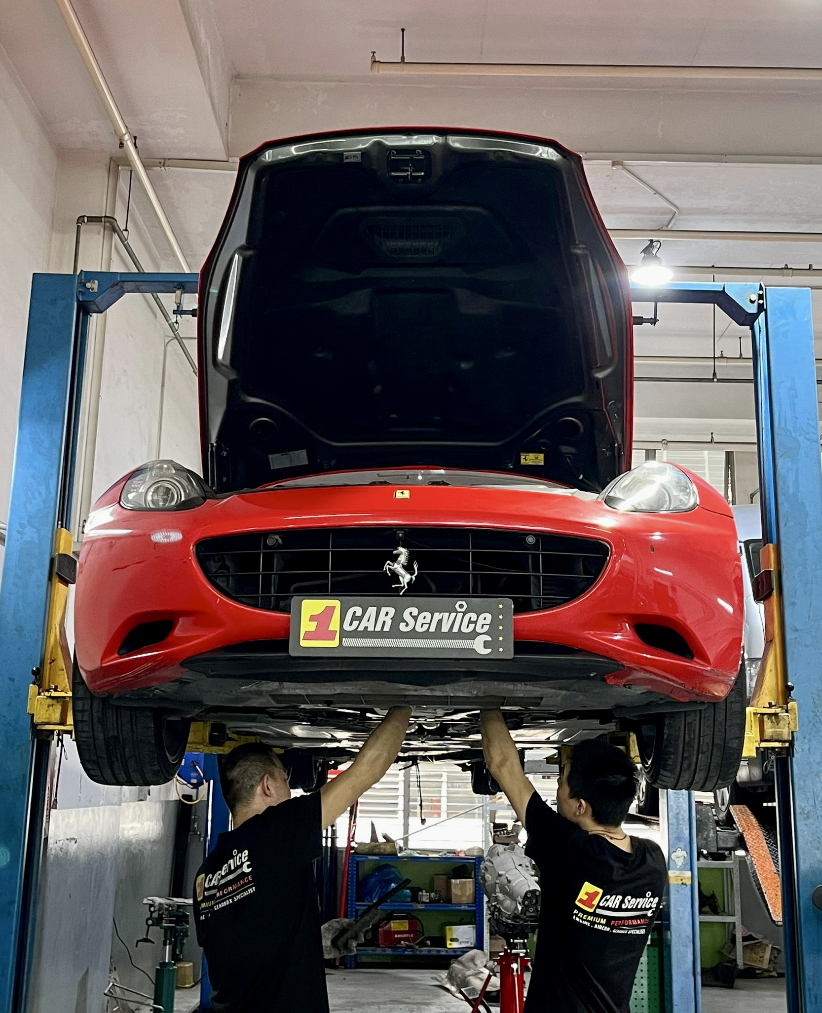 Technicians working on a Ferrari in a state-of-the-art workshop.